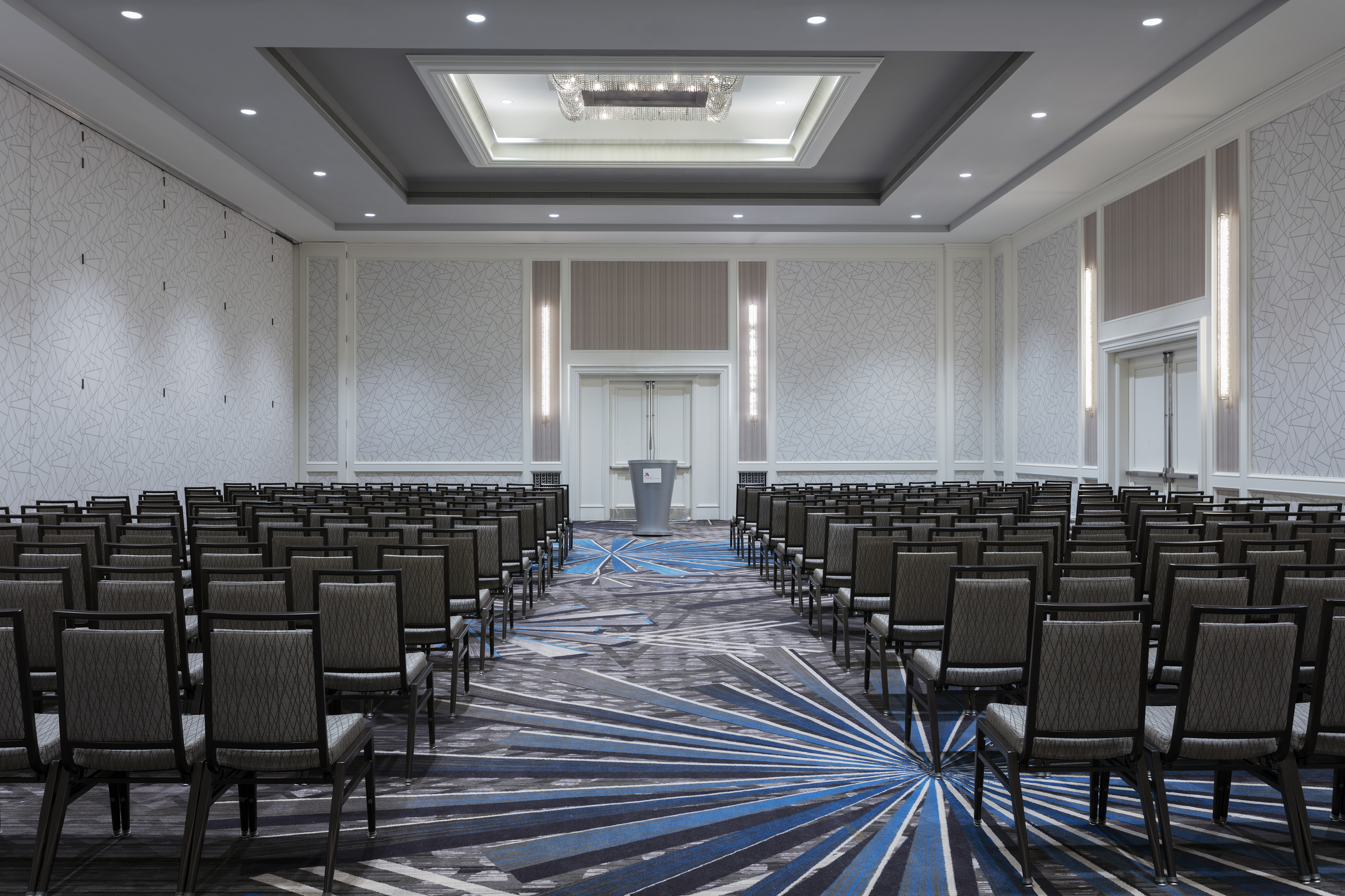 Ballroom set up with theater-style aisles of chairs facing podium