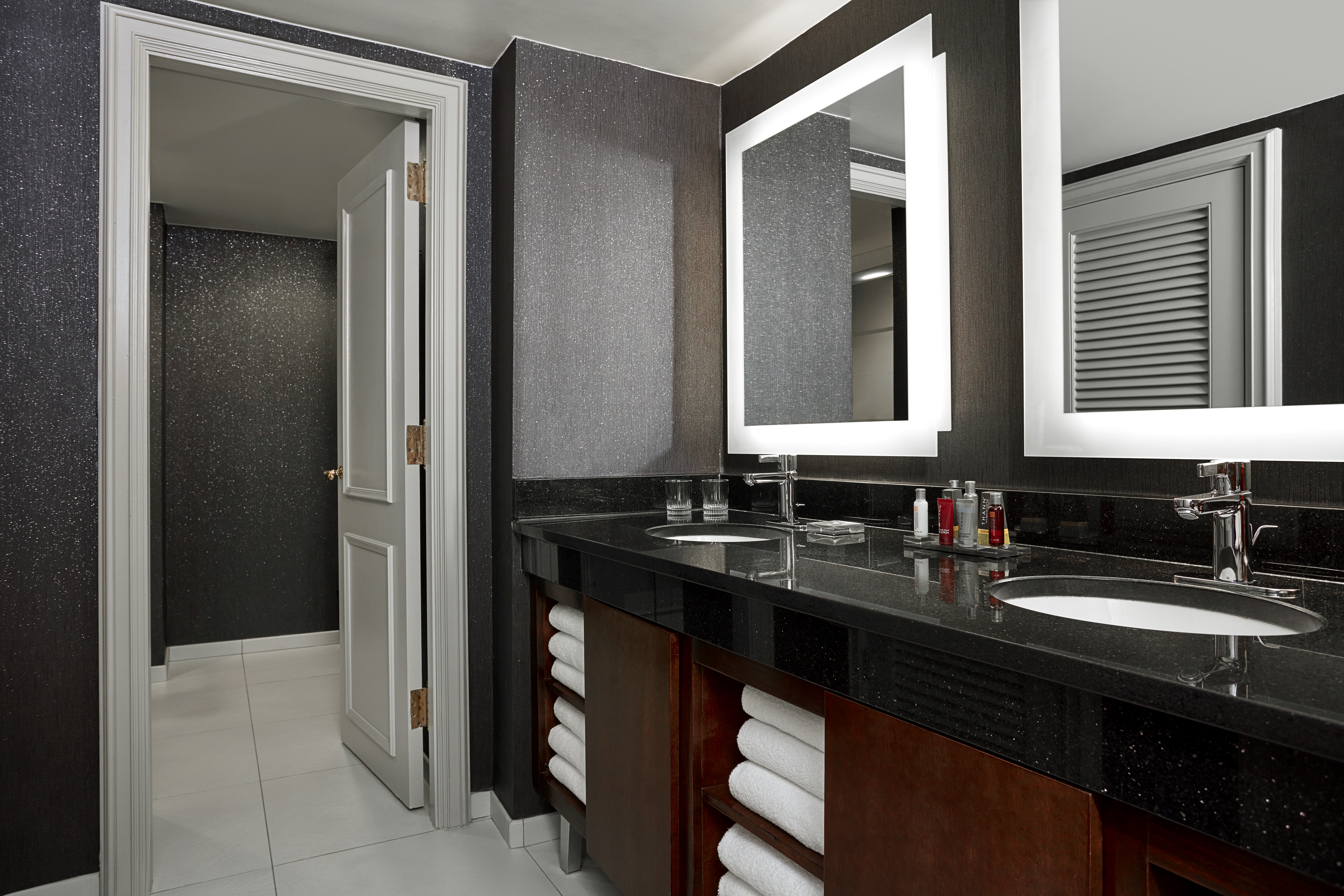 Bathroom with dark brown furniture, large mirrors and two sinks