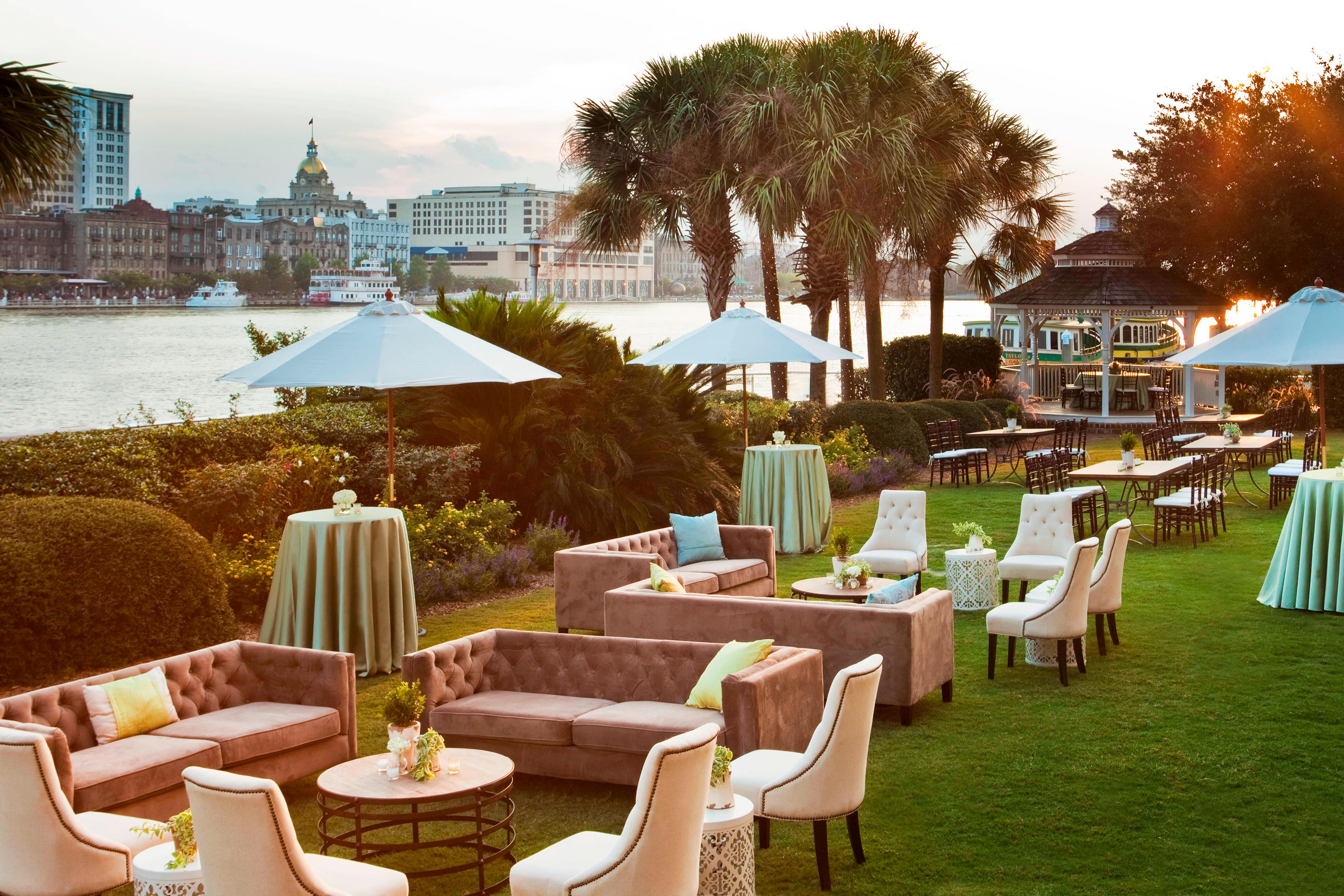 Harbor Lawn with waterfront view set for wedding event with upholstered chairs and sofas