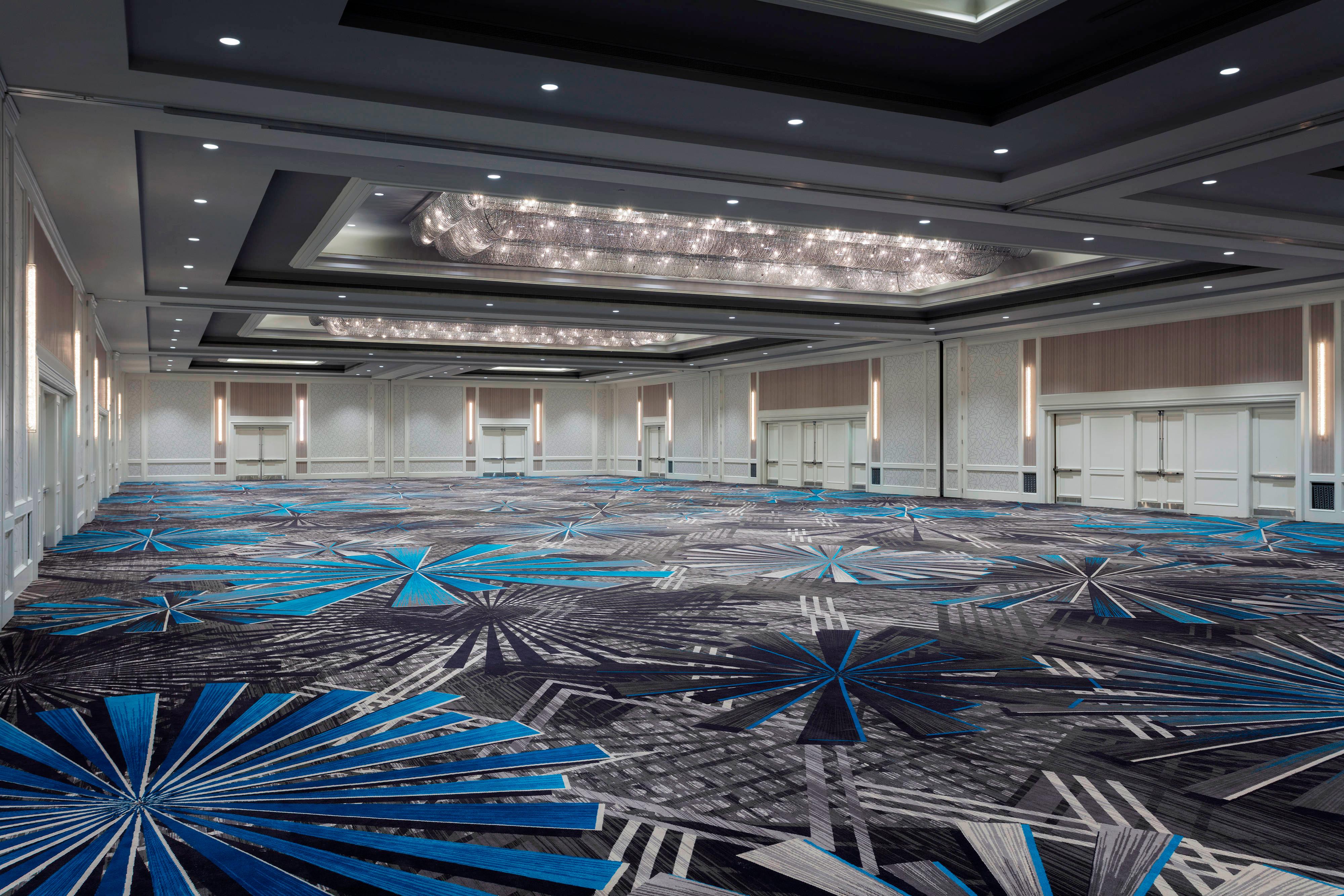Large ballroom with blue-and-gray geometric starburst patterned carpet